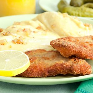 Lunch with schnitzel, potato mash and cucumber on background. Selective focus, shallow DOF..