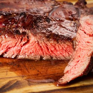 medium roast rib-eye steak on wooden background