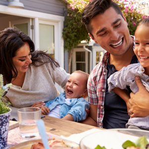Family At Home Eating Outdoor Meal In Garden Together