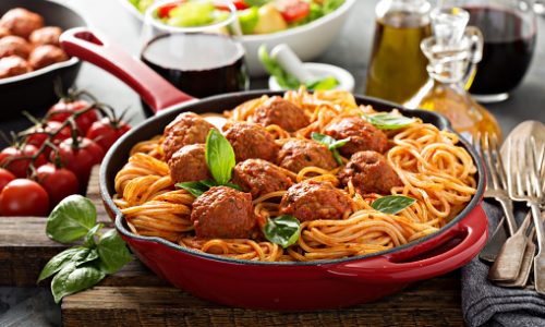 Spaghetti with tomato sauce and meatballs, fresh vegetable salad and red wine